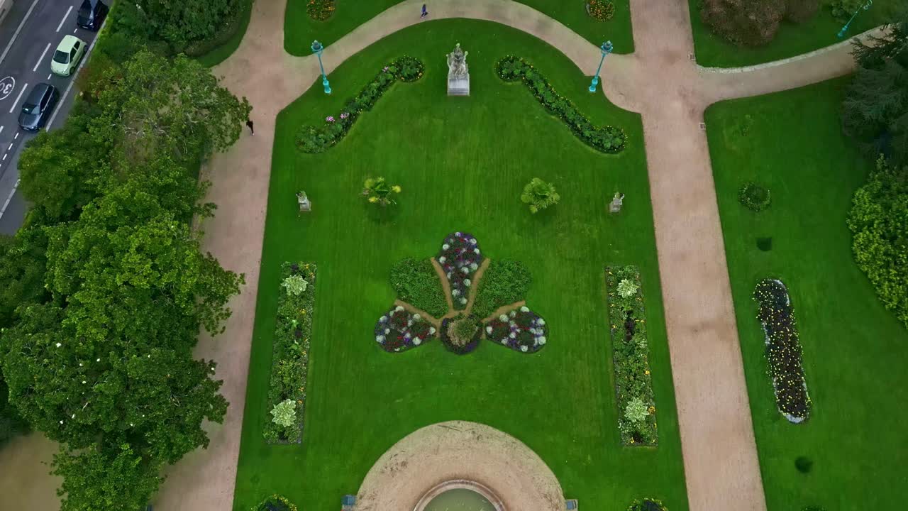 Drone flying over Thabor gardens with fountains and flower beds, Rennes in France. Aerial drone top-down backward