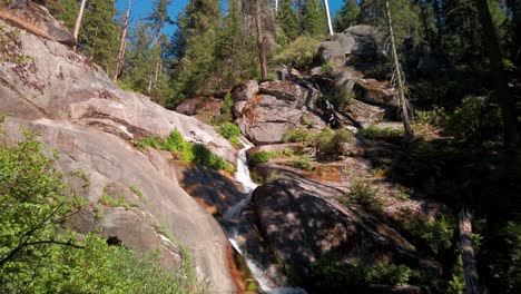 Toma-Panorámica-Siguiendo-La-Cascada-De-La-Montaña-Que-Fluye-A-Través-De-Las-Rocas