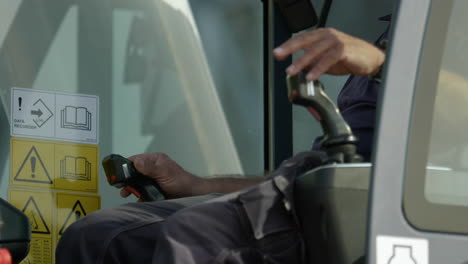 male construction crane operator hands controlling joysticks close up