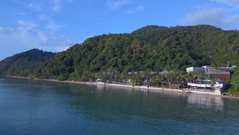 Lovely-aerial-top-view-flight-Beach-Village-Huts-Resort,-tropical-Bungalows-on-Mountainous-Island-Thailand-2022