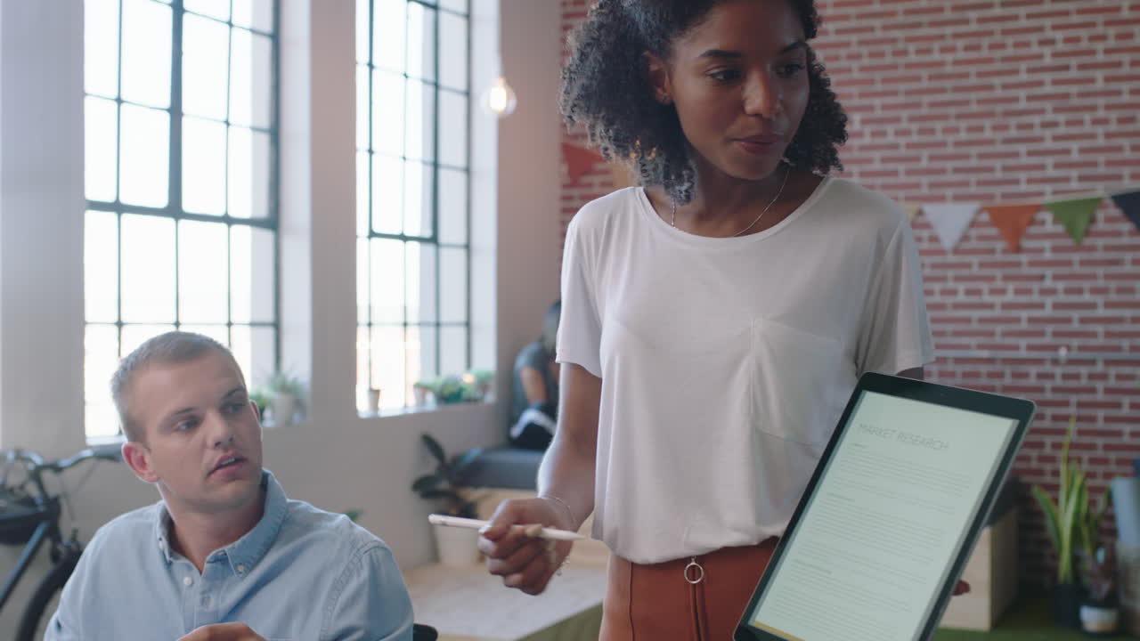 jóvenes empresarios se reúnen líder de equipo mujer presentando datos financieros utilizando una tableta mostrando colegas multiétnicos ideas de marketing en la presentación de la sala de juntas de la oficina