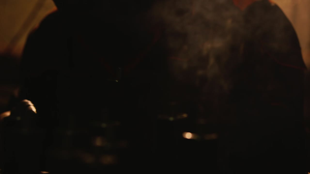 A welder in a protective helmet and clothes welds as sparks fly