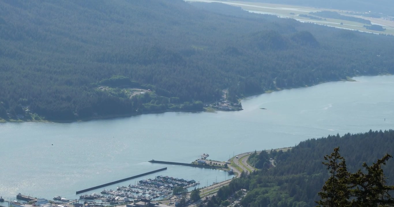 Cabina della funivia Juneau Goldbelt che scende lentamente alla stazione a valle dal Monte Roberts. Splendida vista sul canale Gastineau, sulla città di Juneau e sulle zone umide di Mendenhall
