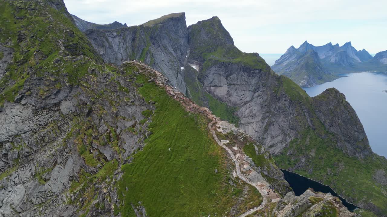 la gente camina por las escaleras a reinebringen punto de vista en las islas lofoten, noruega - 4k aérea