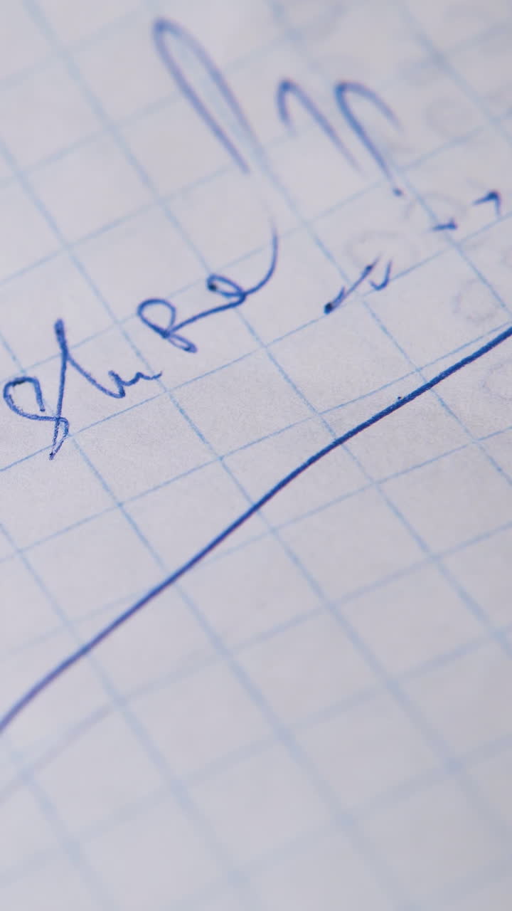 young man writes question ARE YOU SURE with blue ball pen on blank checkered paper sheet extreme close view