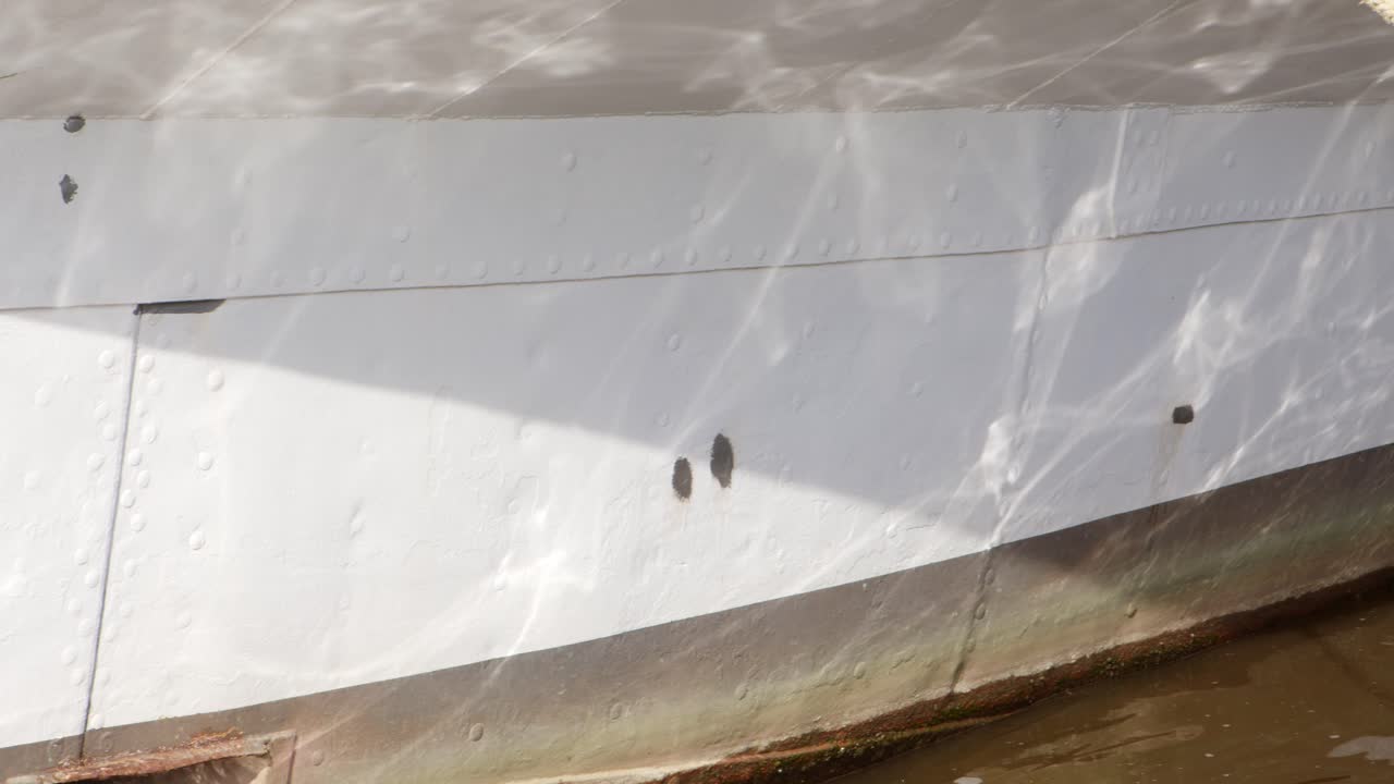 Panning over water reflections on a ships bow