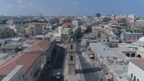 drone aerial shot at the clock tower in jaffa - tel aviv, israel. tourist monument at middle east city with coexist residential life.