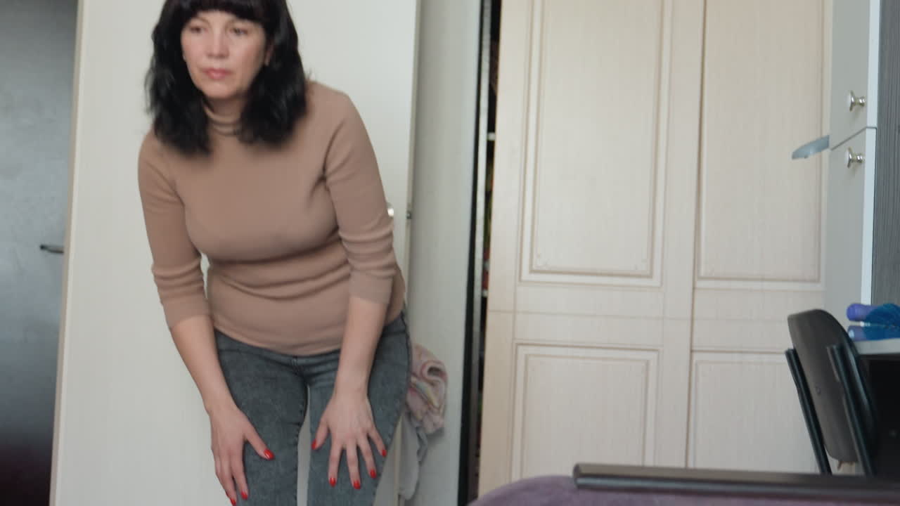 Female Gently Touches Her Pet Inside Home, Woman Softly Interacts With Her Cat In Comfortable Indoor Environment, Woman Lovingly Caresses Her Cat Within Warm And Inviting Apartment Setting