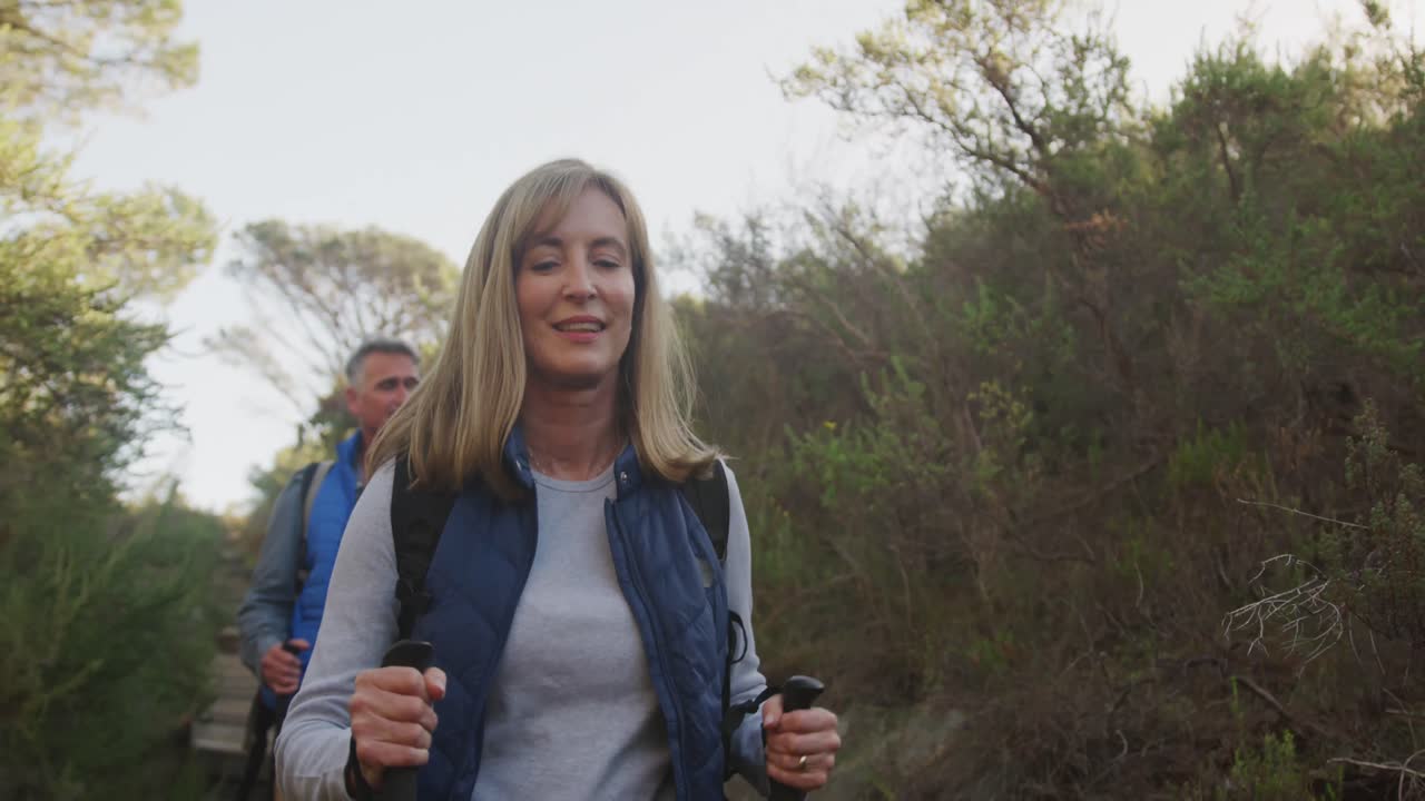 Coppia di anziani attivi che fa trekking nel bosco