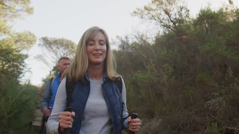 active senior couple hiking in forest