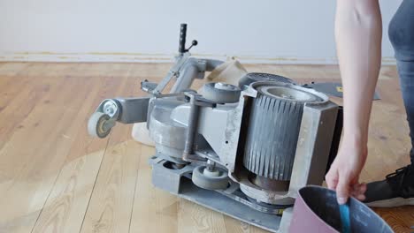 person prepares industrial sanding machine to renovate home floor