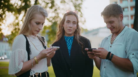 friends looking at phones outdoors