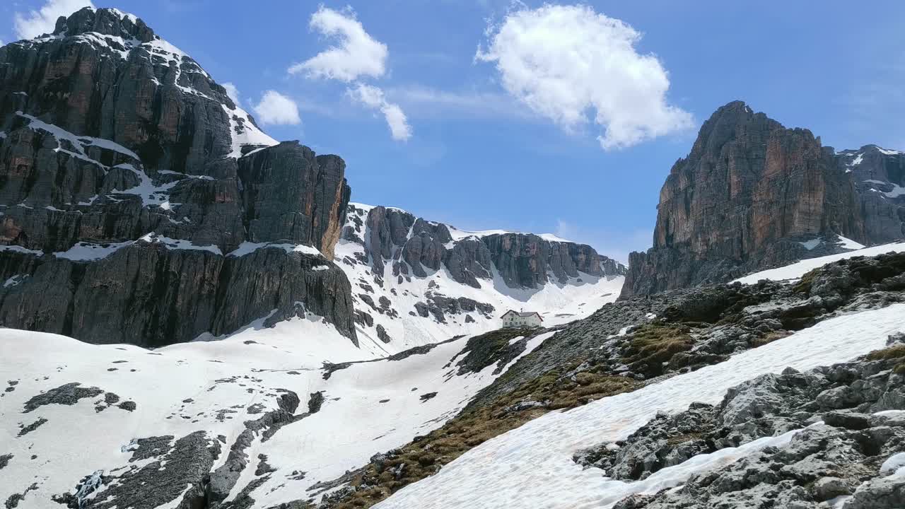 Breathtaking Alpine Landscape with Snow-Covered Mountains and a Mountain Hut