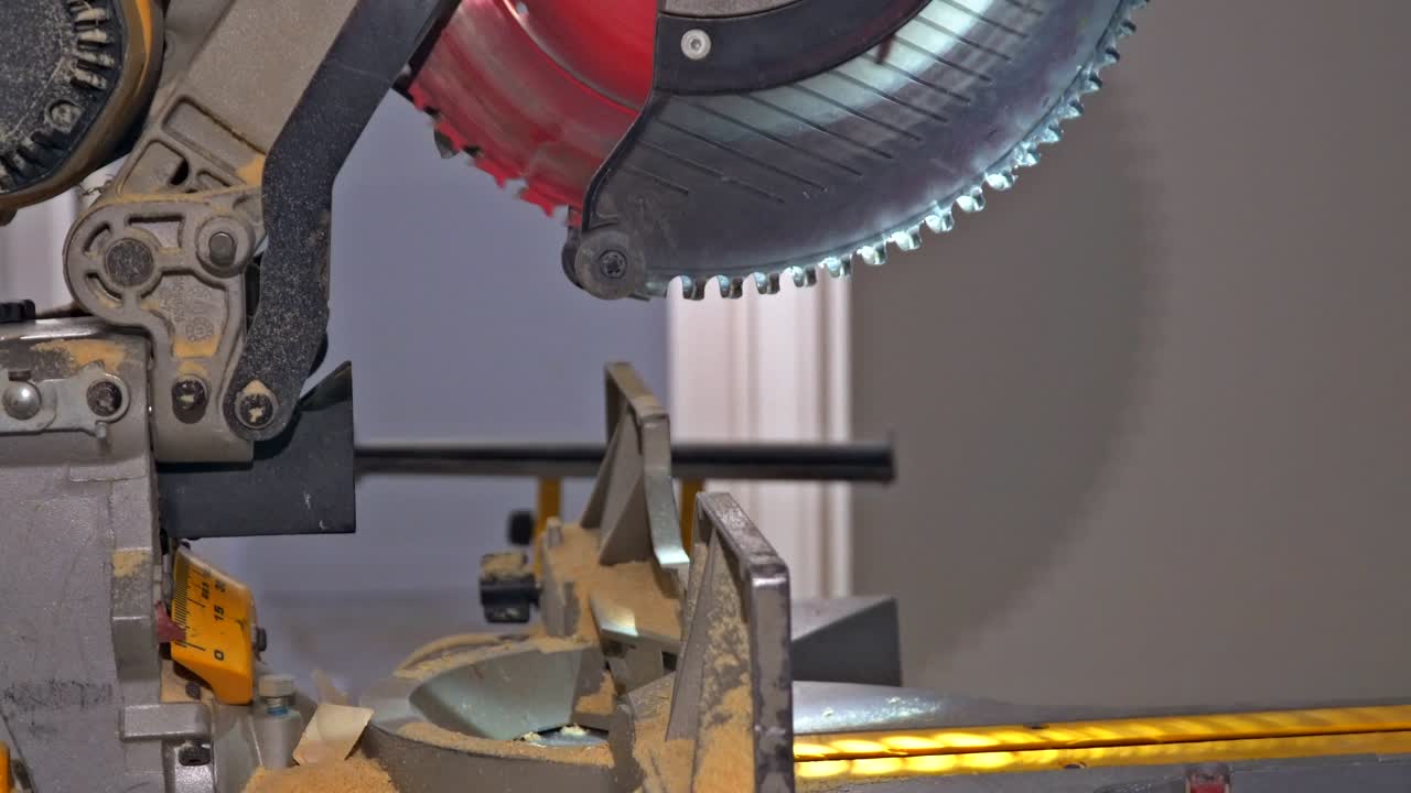 Carpenter cutting wooden trim board on with circular saw. Woodworker works on remodeling home