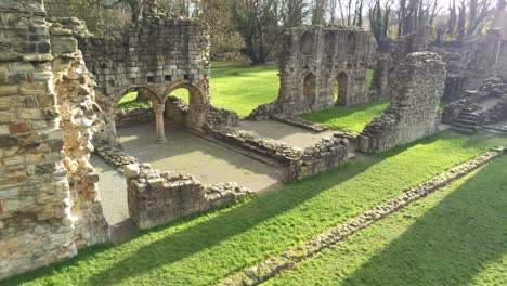 basingwerk abbey landmark medieval abandoned welsh ruins aerial view descending close tilt up