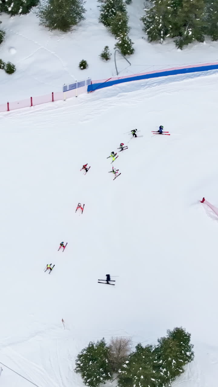 Aerial drone view of people having a ski lesson, at a ski resort in Corvara in Badia covered in snow, in South Tyrol, the Dolomites. Vertical