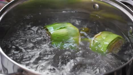 y cocinar alcachofas en una sartén, de cerca en la cocina