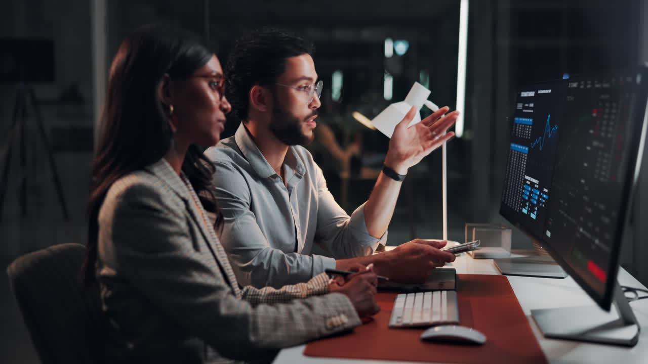 Business Professionals Discussing Data on Computer in Dark Office