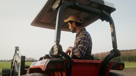 agricultor conduciendo un tractor en un campo