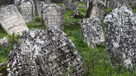 Toma-De-Cámara-De-Mano-Cercana-De-Piedras-De-Pulgar-Con-Inscripción-Hebrea-En-Un-Antiguo-Cementerio-Judío-En-El-Pueblo-Rascov-En-Transnistria,-La-República-De-Moldavia-Pridnestrovian---Establecimiento-De-Eshot-2023