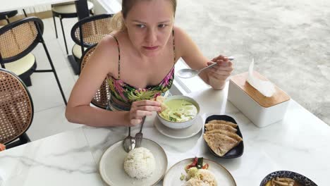 woman enjoying a thai green curry meal