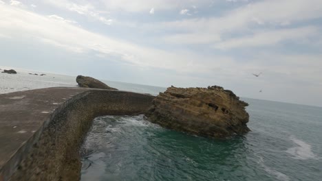 drone flying over rocky pier of biarritz, pyrenees atlantiques, french basque country