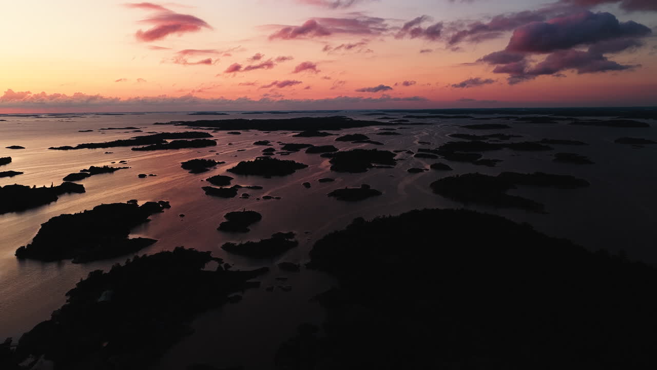 Luftfoto af silhuetøer i den ydre skærgård ved solnedgang i Oro, Finland.