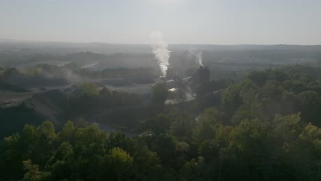 wide aerial footage of a smokestack in the early morning in kennesaw, georgia