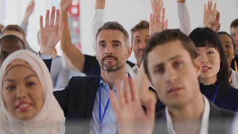 Audience-at-a-seminar-raising-hands-to-ask-questions