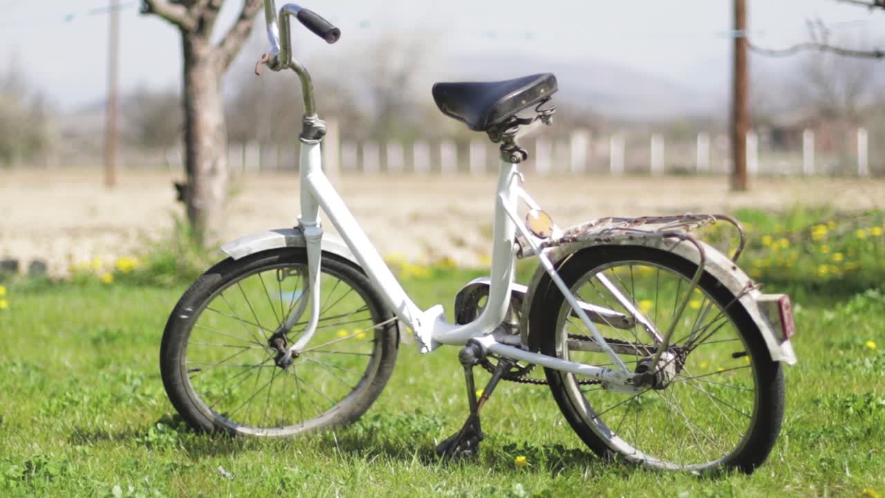 Old white bicycle on a meadow. Old timer bike. Transportation. Cycling.