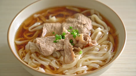 homemade udon ramen noodles with pork in soy or shoyu soup