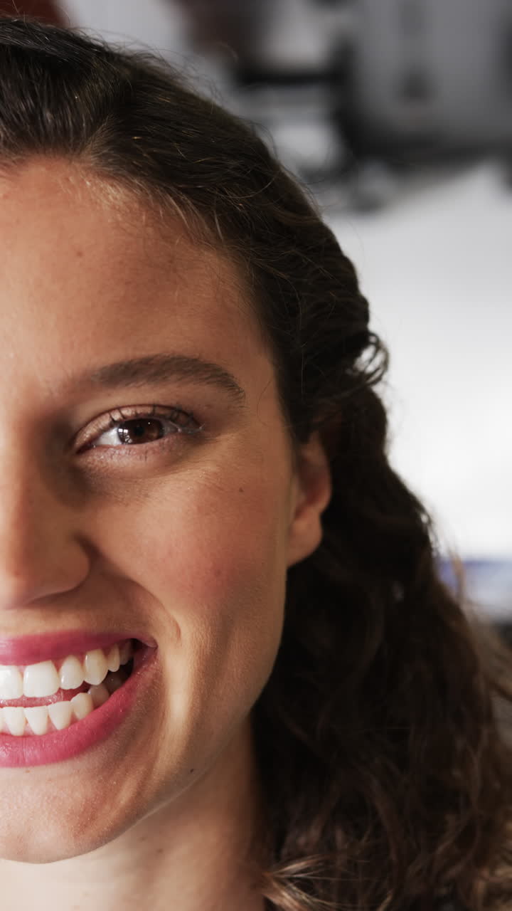 Vertical video of half portrait of happy caucasian businesswoman in casual office, slow motion