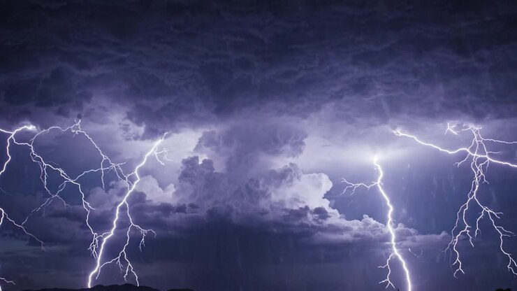Maestose nuvole temporalesche illuminate da fulmini lampeggianti che creano un cielo drammatico in uno spettacolo notturno della potenza e bellezza della natura