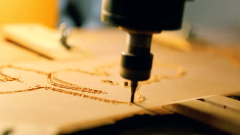 cnc drill is drilling on the wooden plank. in the woodworkers shop the cnc drill is drilling on the wooden plank
