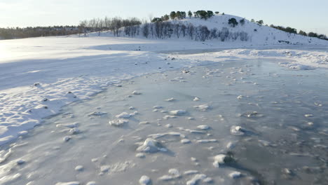 Low-Flying-Drone-Shot-Over-an-Icy-Coastline-in-a-Snowy-Environment