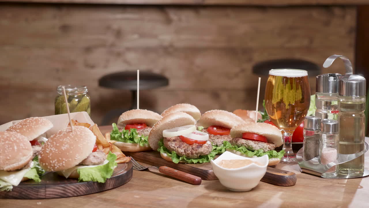 Close-up of Burgers, Fries, and Beer on a Wooden Table