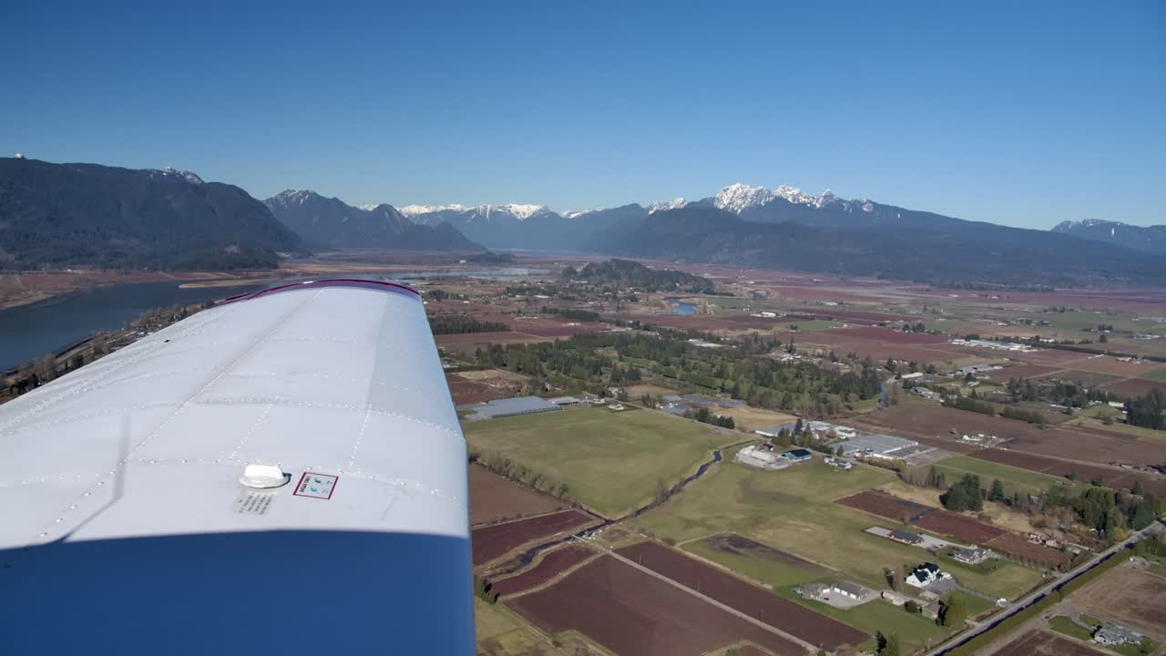 punta del ala de un avión volando en un hermoso paisaje montañoso soleado
