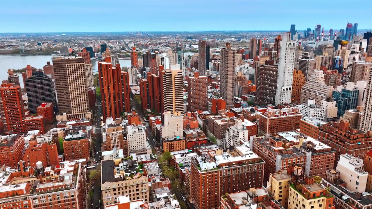 Volando sopra il paesaggio di New York con edifici vari. Centro di una vivace metropoli con un fiume sullo sfondo, visto dall'alto.