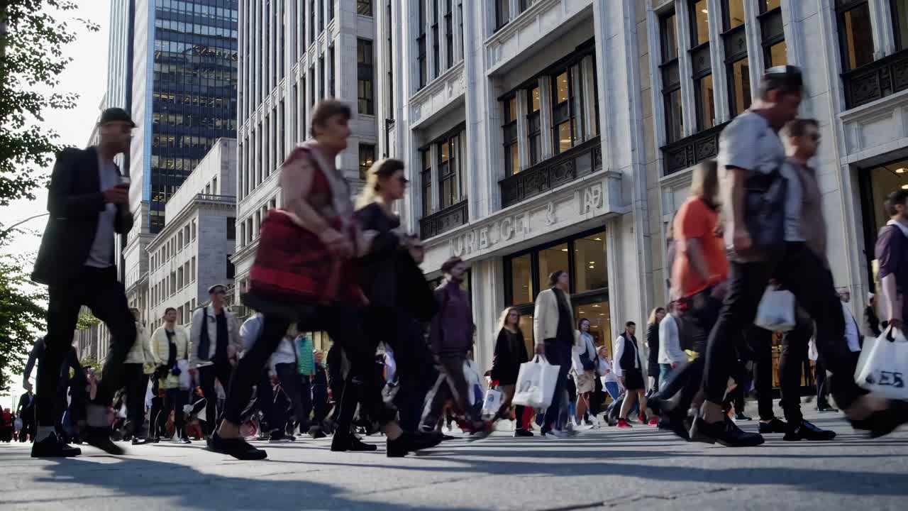 Video con angolazione dal basso di una strada trafficata, che cattura diversi pedoni in movimento
