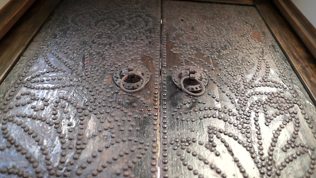 Big heavy wooden doors with brass detail, close up low angle,