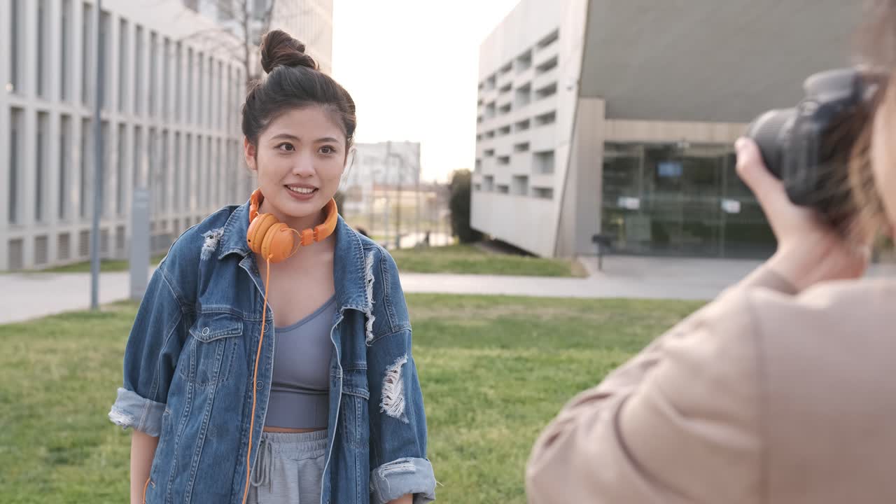 Young asian woman posing to the camera while someone taking a photo to her.