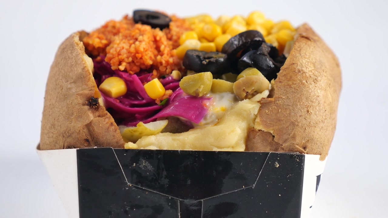 Patata al forno ripiena di verdure e condimenti