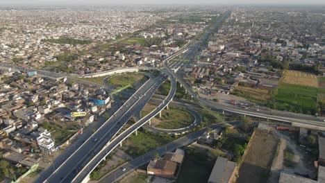 4k: avión no tripulado volando sobre un paso elevado de tráfico con tráfico urbano en curso en punjab, pakistán