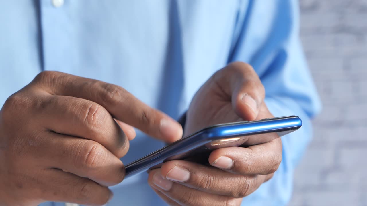primer plano de las manos de un hombre usando un teléfono inteligente