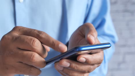 close-up of a man's hands using a smartphone