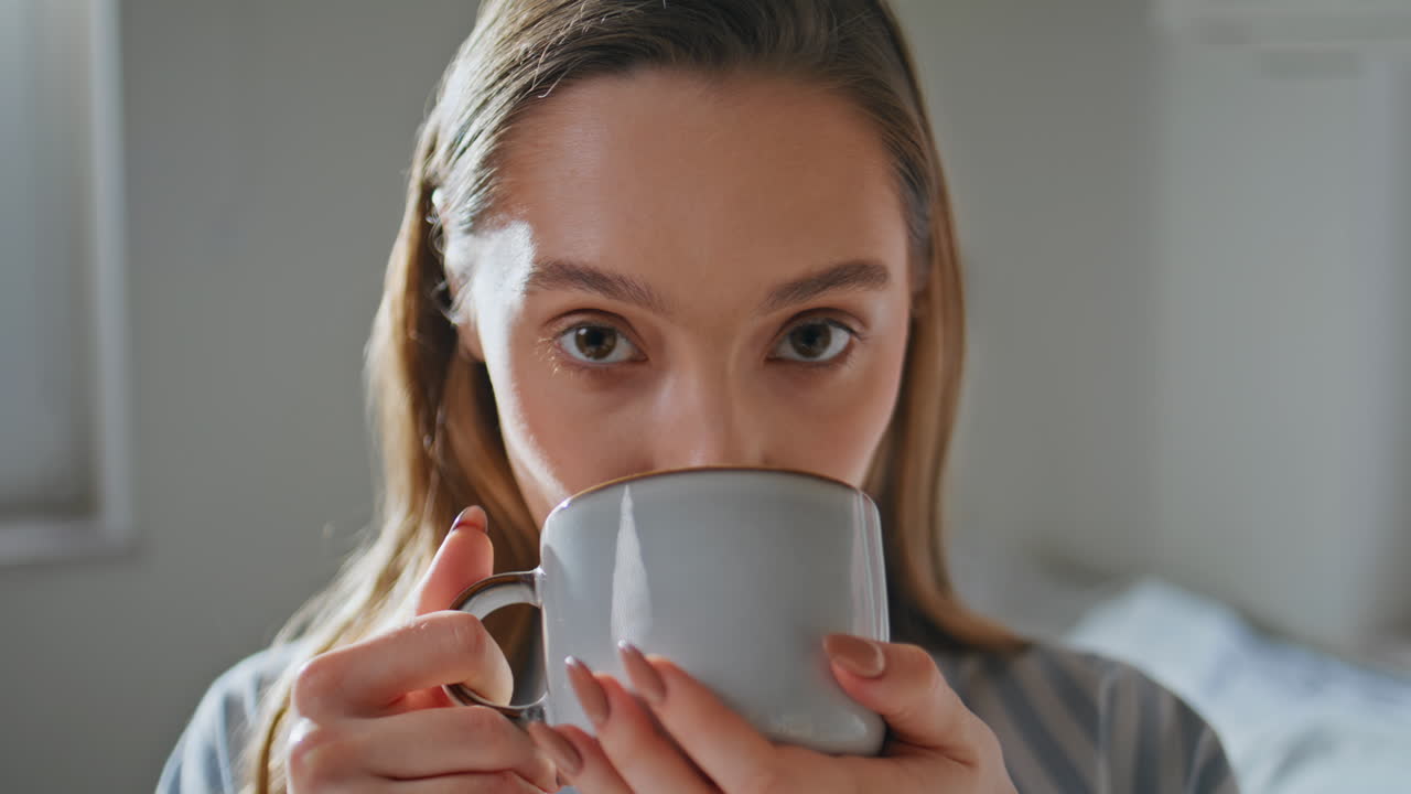 Homely woman savoring coffee in bedroom closeup. Relaxed girl drinking beverage