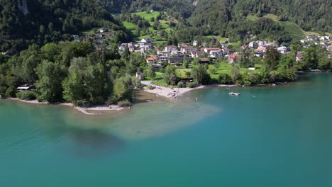 Side-lake-beach-in-swiss-mountain-village-green-town-in-pine-tree-forest-foothill-highlands-scenic-wonderful-rural-background-in-alpine-region-Europe-Switzerland-Walensee-weesen-walenstadt-amden-alps