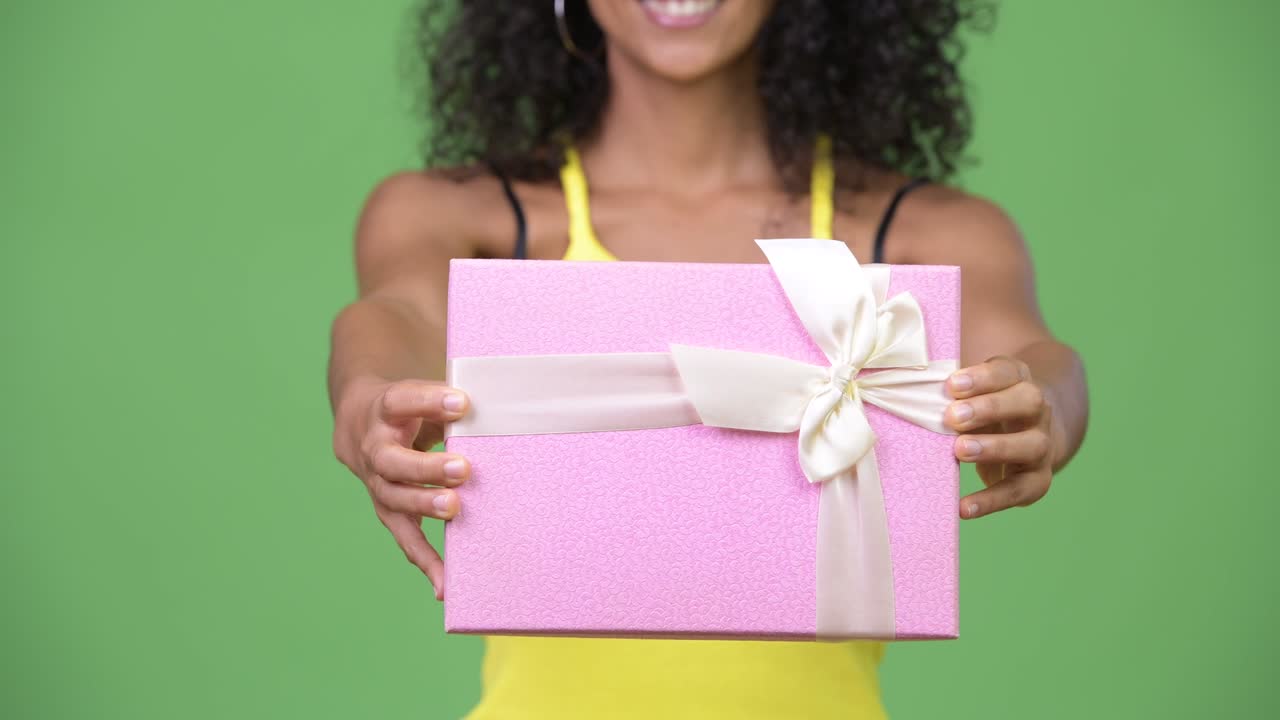 Young beautiful Hispanic woman giving gift box