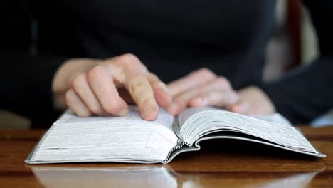 mujer rezando con la biblia en la mesa con fondo negro con la gente almacen de video