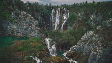 cinemagrafía 4k uhd de agua azul fresca que fluye por hermosas cascadas entre un puente peatonal de madera en el famoso parque nacional de plitvice en croacia, donde se filmaron las películas clásicas de winnetou